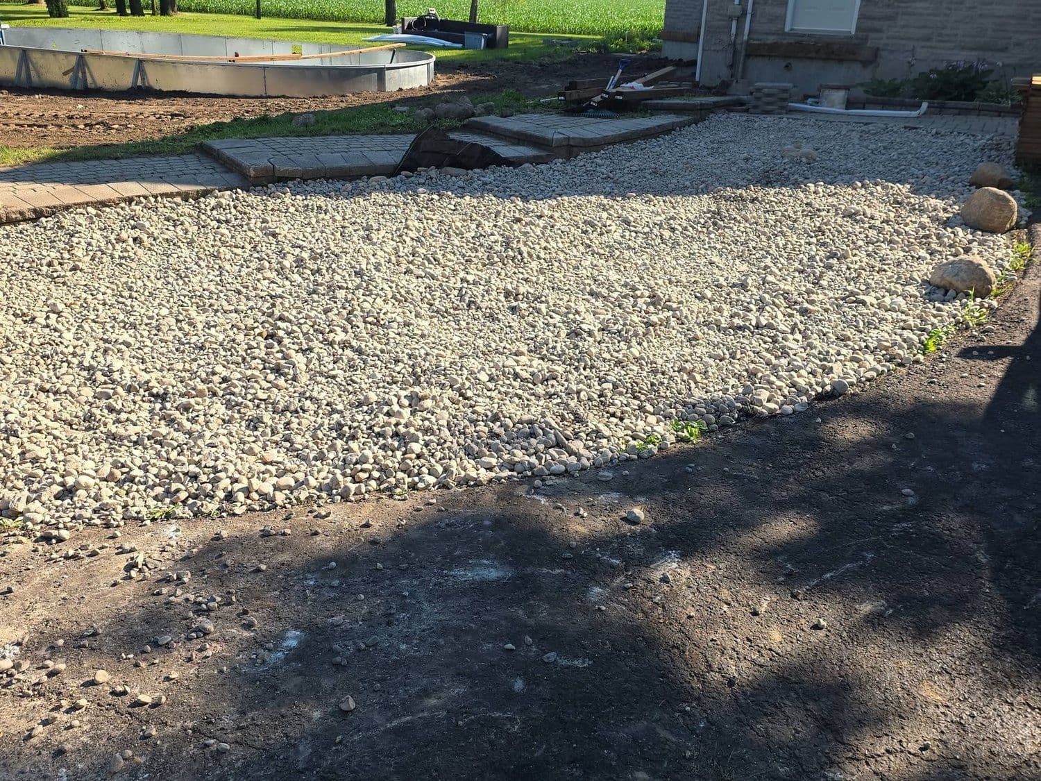 Two-tone river wash stone graded beside a curved paver walkway